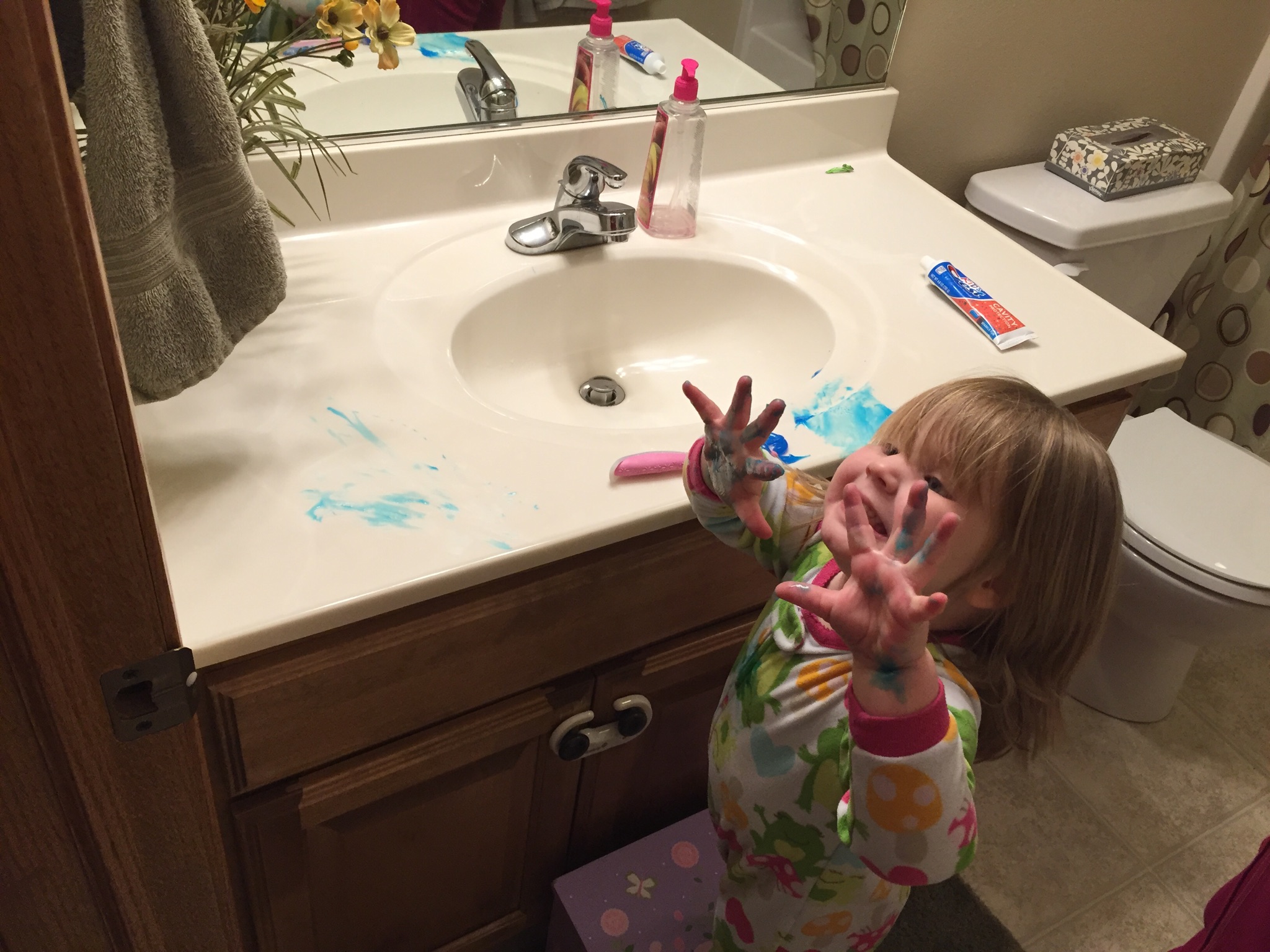 little girl with toothpaste on hands